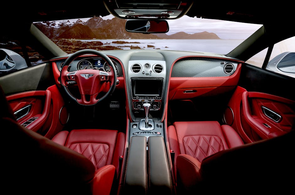 Red leather luxury sports car interior with mountain backdrop outside the window