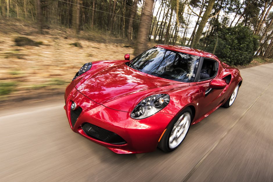 A sleek red sports car driving fast on a forest road, showcasing speed and luxury