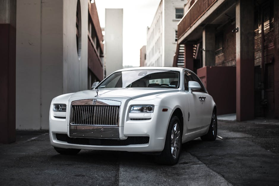 Elegant white luxury car parked in an urban alley, exuding sophistication and style