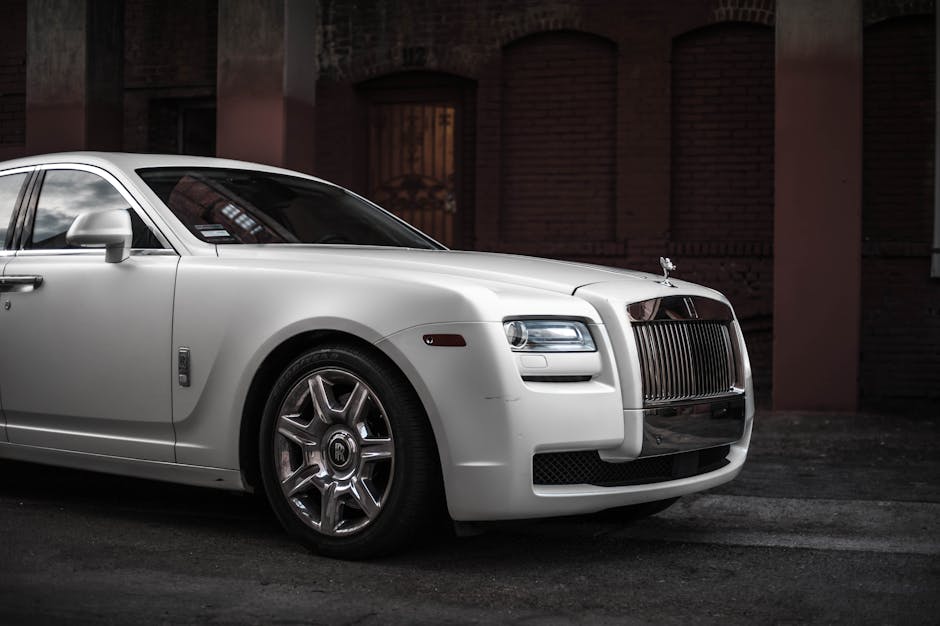 Elegant white Rolls Royce Ghost parked in a stylish urban backdrop, showcasing luxury and design