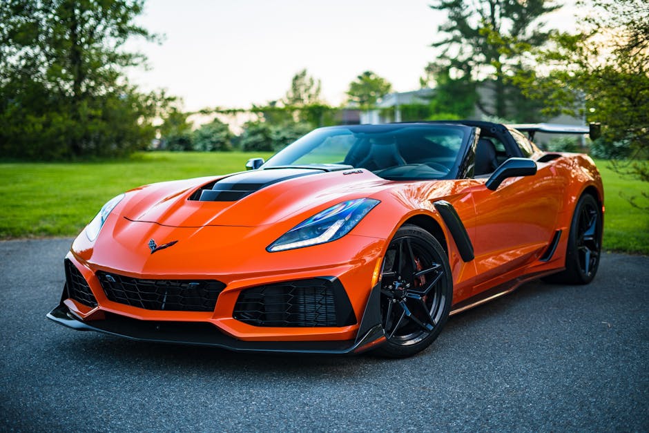 A sleek orange convertible sports car elegantly parked on a scenic outdoor road
