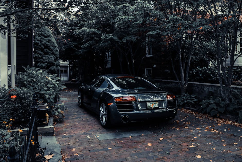 A sleek Audi R8 parked in a leafy residential driveway in Cape May, NJ, showcasing elegance and luxury