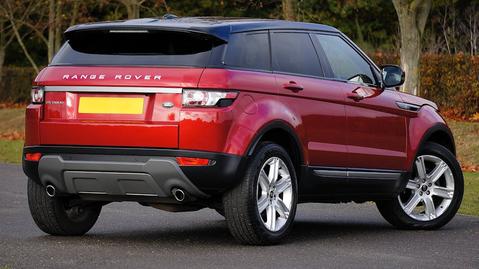 Elegant red Range Rover SUV parked outdoors on a clear day, showcasing its luxury and style