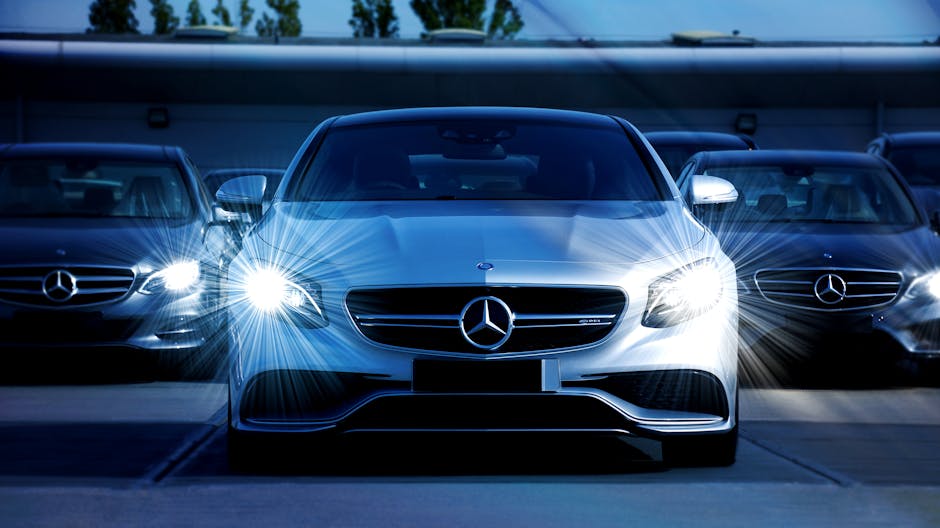 Front view of a lineup of Mercedes-Benz cars with bright headlights, showcasing luxury and elegance